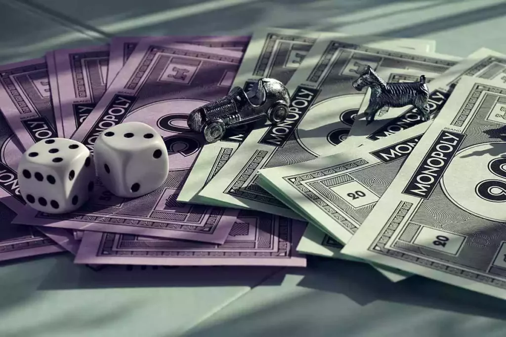 Dices and figurines on Monopoly money while playing a board game.