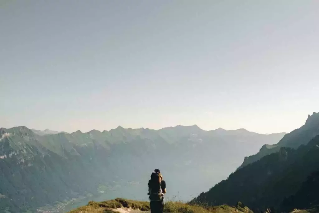 Man over 30 with a backpack faced with a breathtaking mountain view while hobby hiking.