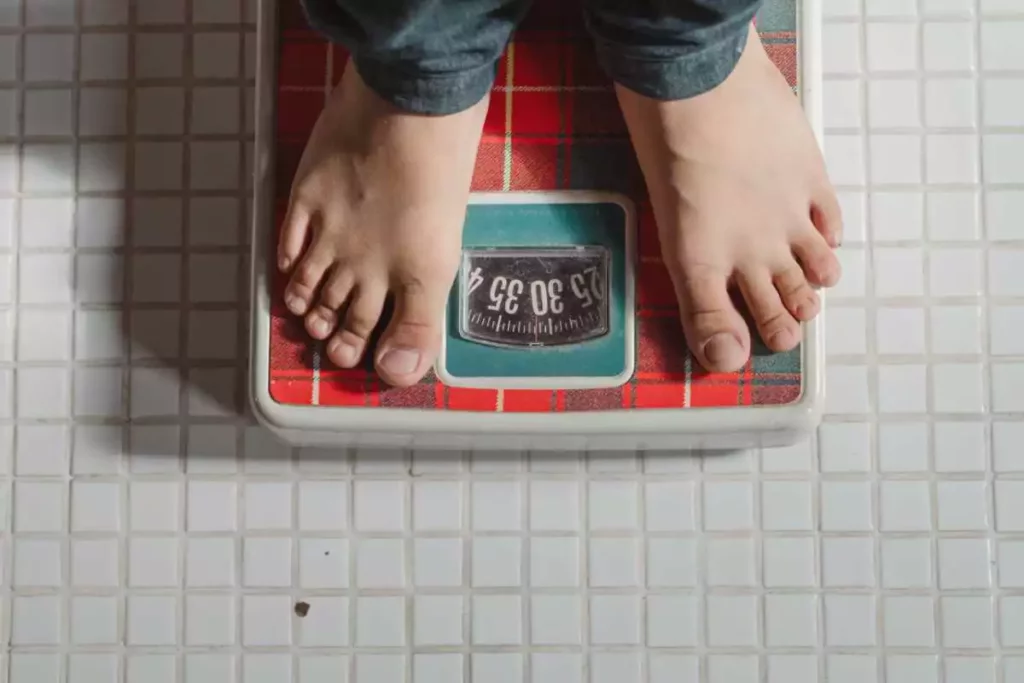 Man using the scale to his weight loss progress.