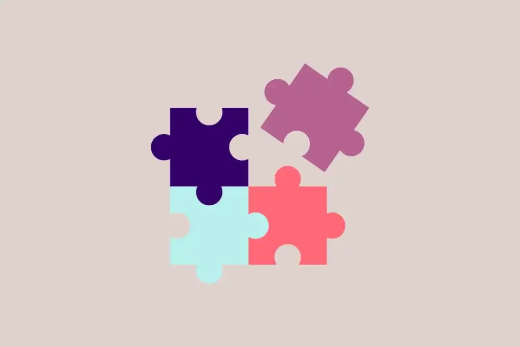 Four pieces of the jigsaw puzzle in blue, purple, cyan, and red colors on a beige background. 
