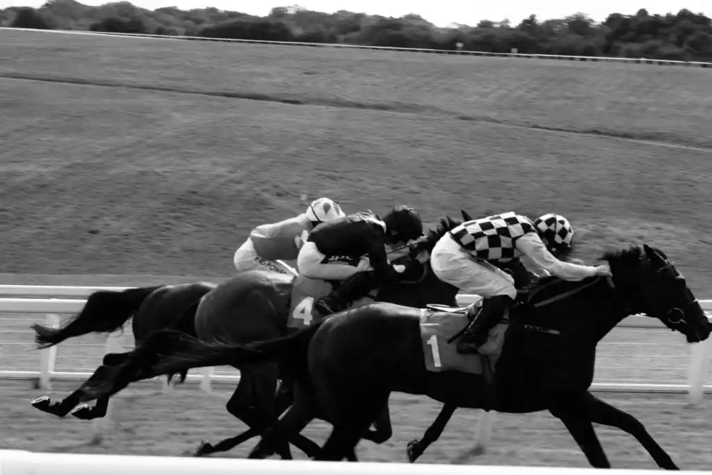 A black and white photograph showing short jockeys horse riding, as it is one of the most suitable sports for short guys.