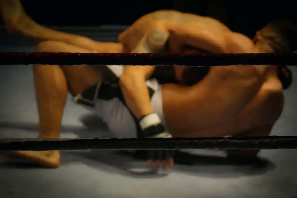 A photograph of two wrestlers wrestling in a ring. Amateur wrestling is one of the best sports short men with proper technique can succeed at. 