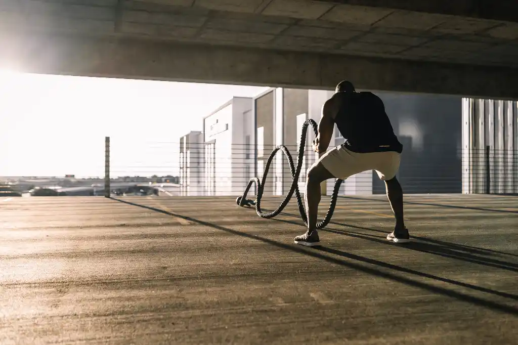 A photograph showing a man working out from the back, doing an exercise to build muscle and grow stronger.