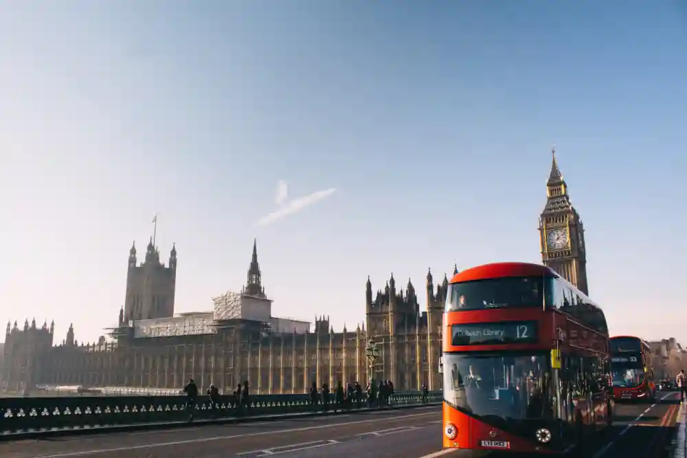 A big, red double-decker bus with Big Ben shown in the background, in London, UK, one of the best places to travel with friends